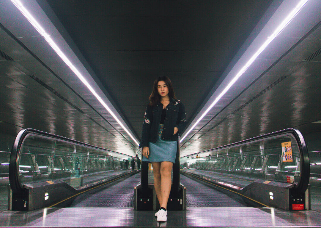 A girl standing between two converging lines